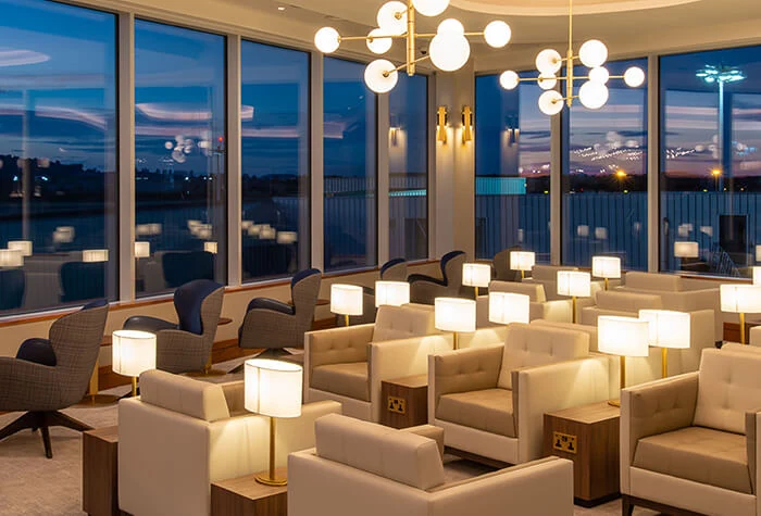 Seating with table lamps inside the Plaza Premium Lounge at Edinburgh Airport