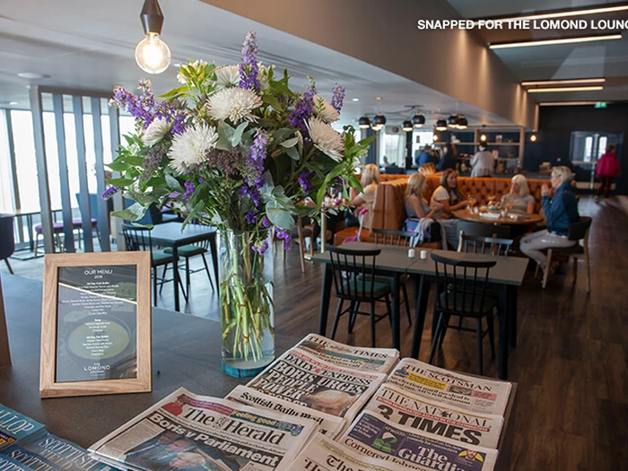 Floral display and seating inside The Lomond Lounge at Glasgow Airport