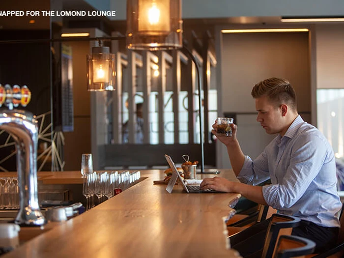 Guests relaxing with drinks in The Lomond Lounge at Glasgow Airport