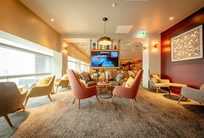 Interior seating area with armchairs and tables in My Lounge, Heathrow Terminal 3
