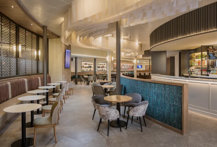 Seating and tables beside the bar in the Aspire Lounge at Liverpool Airport