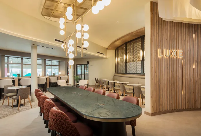 Large shared table and lounge seating inside Aspire Luxe at Liverpool Airport