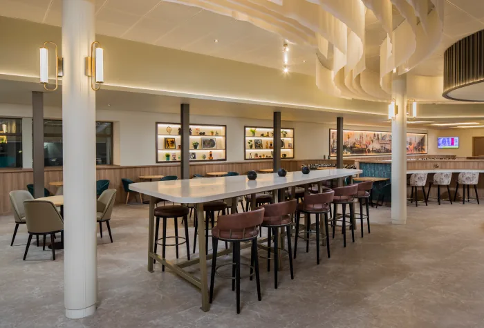 High stools and communal seating area inside the Aspire Lounge at Liverpool Airport