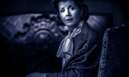 Vivid production stills from The Mousetrap Musical, portraying an actress in period attire looking over her shoulder with a startled expression, enhancing the suspenseful atmosphere of the scene.