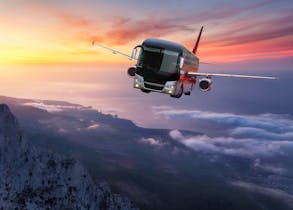 A surreal composite of a coach-style bus merged with an airplane's fuselage and wings, flying above misty mountain peaks at sunset.