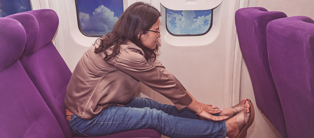 Frau streckt sich im Flugzeug