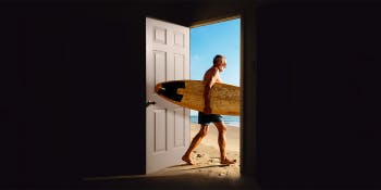 Hassle-free travel: A step-by-step guide | A man with surfboard walking through a door out to the beach