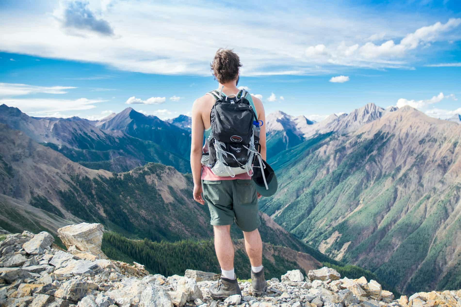 a backpacker on a hilsside surveying the landscape