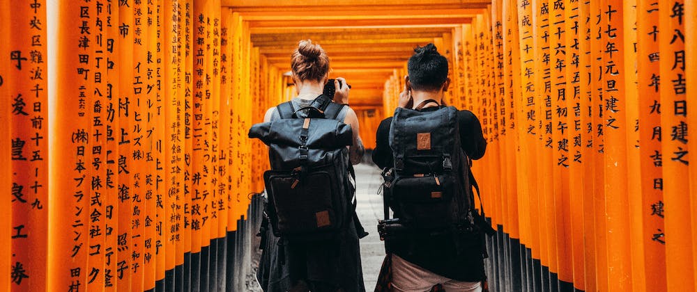 Two backpackers exploring a Japanese shrine