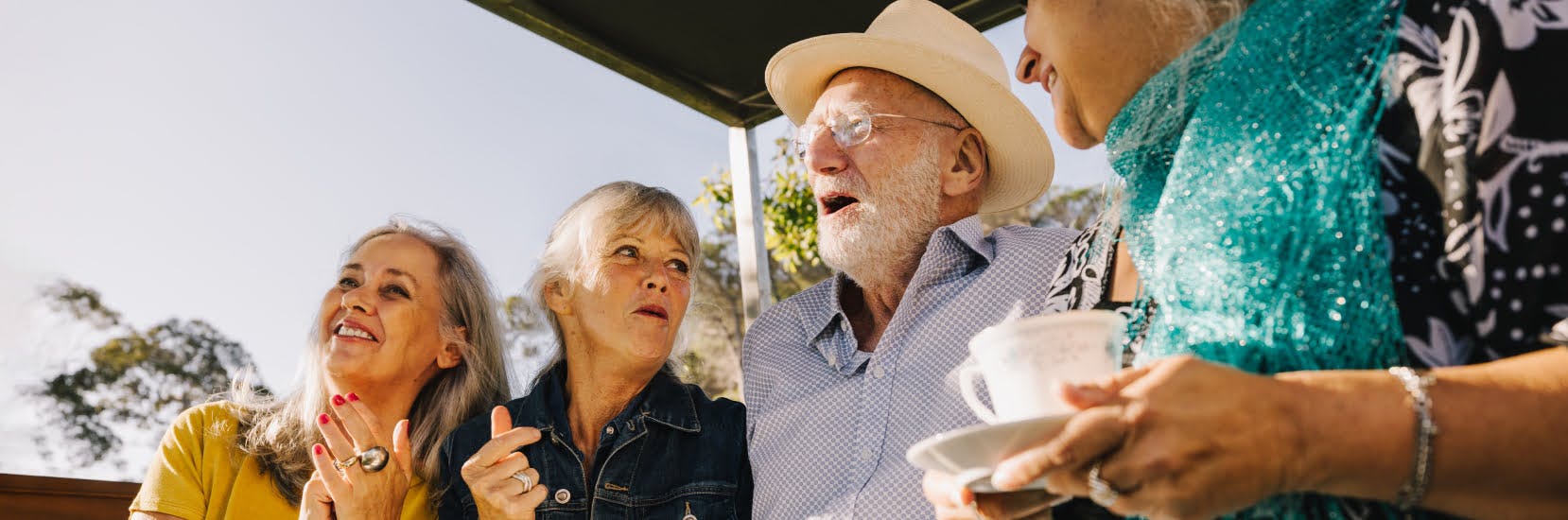 A joyful group of older friends enjoying time together outdoors, symbolising the freedom and peace of mind that comes with reliable travel insurance for over 90's.