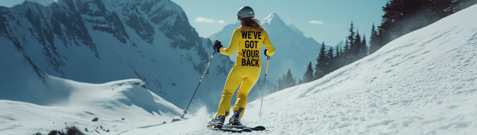 A skier wearing a bright yellow ski suit with the words 