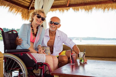 Älteres Paar mit Frau im Rollstuhl bei einem Landausflug