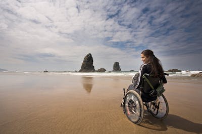 Frau im Rollstuhl am Strand