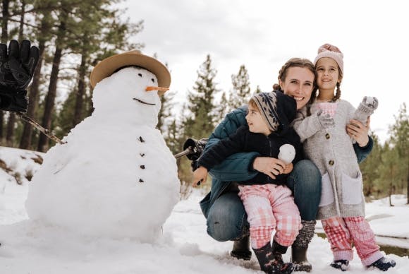 Family of three building a snowman